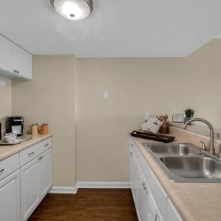A modern kitchen with white cabinets and appliances.