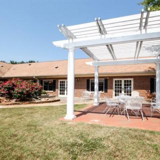 A backyard patio with a pergola and outdoor seating area.