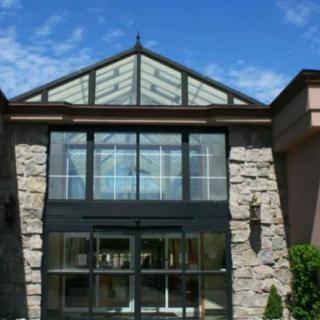 A modern building with a stone facade and large glass entrance.