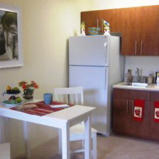 A cozy kitchen with a dining table, chairs, and essential appliances.