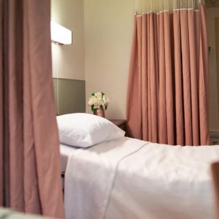 A serene spa setting featuring a massage table with pink curtains.