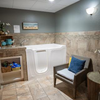 A tranquil bathroom featuring a walk-in tub and comfortable seating.