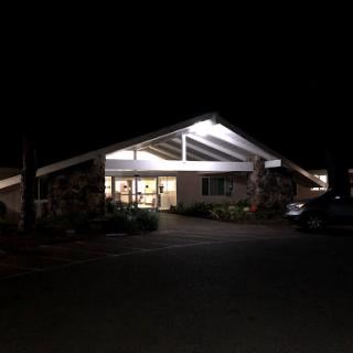 A well-lit modern building at night with a welcoming entrance.