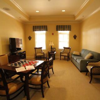 A cozy living room with a dining table, sofa, TV, and chairs.