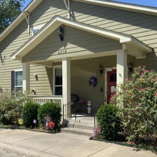 A charming suburban house with a welcoming front porch and well-maintained garden.