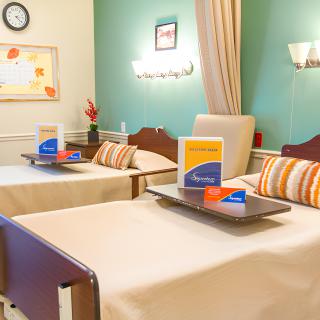 A clean hospital room with two beds and medical equipment.