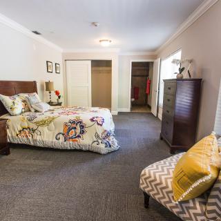 Spacious bedroom with cozy furnishings and open walk-in closets.