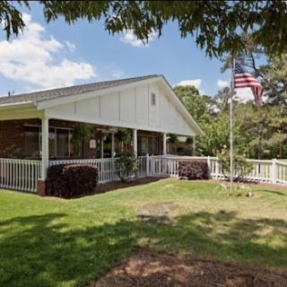 A charming residential house with a well-maintained front yard and an American flag.