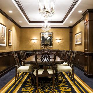 A luxurious and elegant dining room with a chandelier and formal wooden furniture.