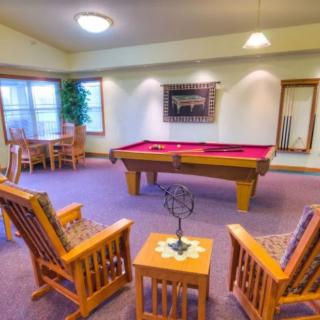 A cozy game room featuring a pool table and comfortable seating.