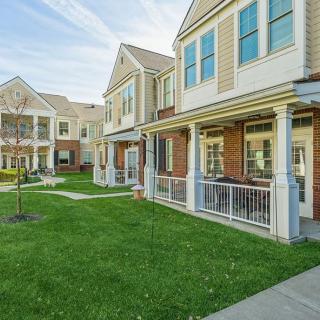 A row of suburban townhouses with neatly maintained lawns and porches.