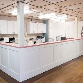 A modern reception area with a large counter and white cabinetry.