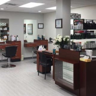 Interior view of a modern hair salon with styling stations and product displays.