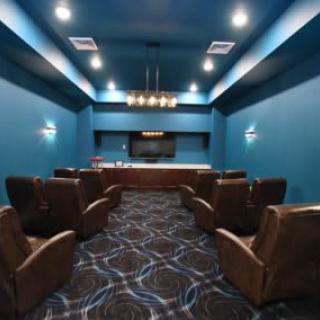 A modern home theater with comfortable seating and a large projector screen.
