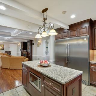 Modern kitchen interior with a central island, granite countertops, and stainless steel appliances.