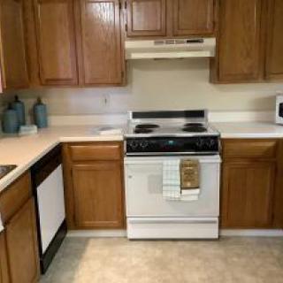 A cozy kitchen with wooden cabinets and standard appliances.