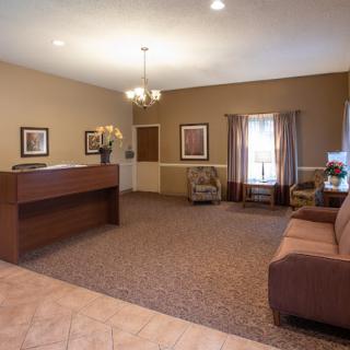 A spacious and warmly decorated lobby area with a reception desk and seating.