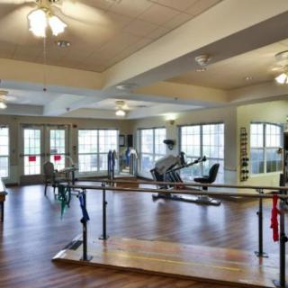 A spacious rehabilitation room equipped with exercise and therapy equipment.