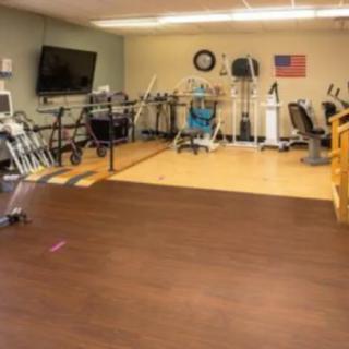 A physical therapy room equipped with various exercise machines for rehabilitation purposes.
