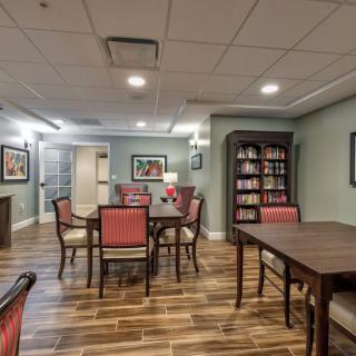 A cozy communal dining area with a bookshelf and comfortable seating.