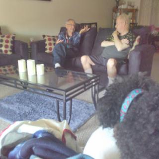 Two individuals engaged in a conversation in a cozy living room setting.