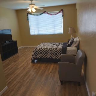 A cozy bedroom with a bed, chair, and television set.