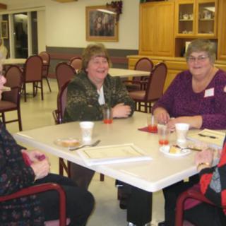 A group of people sitting around a table, enjoying a social gathering indoors.