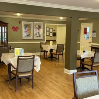 An inviting dining room with neatly arranged tables and chairs on a wooden floor.