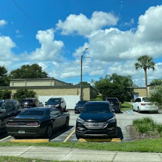 A sunny day at a parking lot filled with various cars under a blue sky.