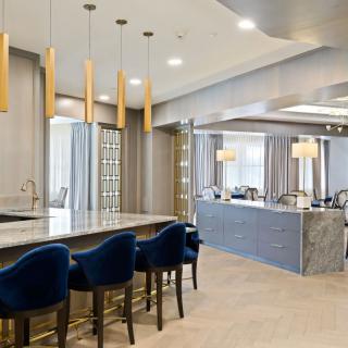 A modern kitchen with elegant bar seating and contemporary lighting.