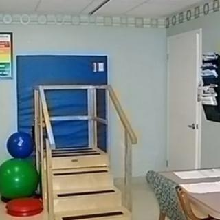 A physical therapy room equipped with stairs, gym balls, and exercise equipment.