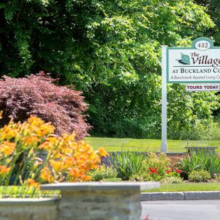 A picturesque entrance sign surrounded by vibrant flowers and lush greenery.