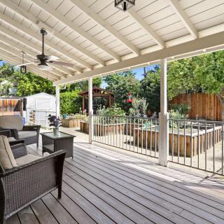 A covered patio with comfortable outdoor seating overlooking a garden.