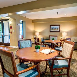 A cozy and well-decorated seating area with tables and chairs, illuminated by soft lighting.