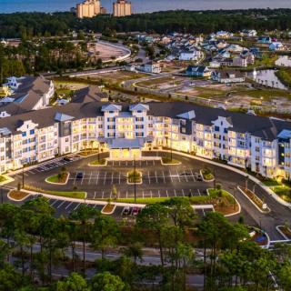 Aerial view of a well-lit residential apartment complex during twilight.