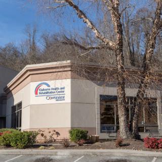 A healthcare facility featuring a modern exterior and surrounded by trees.