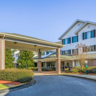 A well-maintained residential building with a covered entrance and landscaped surroundings.