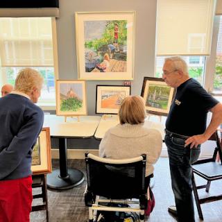 Community members engage in a discussion about the art on display during a local exhibition.