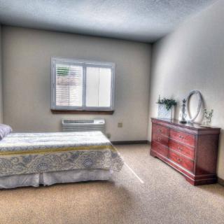 A minimalist bedroom with a single bed and a wooden dresser.