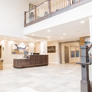 A modern and spacious lobby with a reception desk and balcony.
