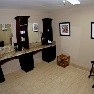 A spacious bathroom with a double sink vanity, large mirrors, and decorative artwork on the walls.