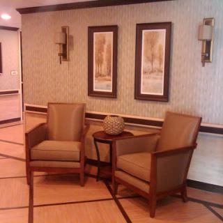 A cozy corner featuring two chairs and decorative wall art.