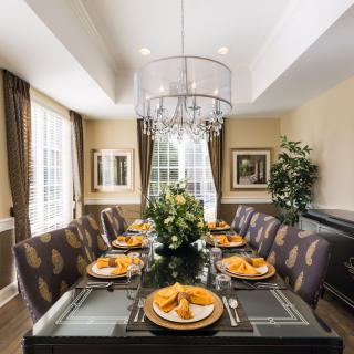 A beautifully decorated dining room with an elegant table setting and chandelier.