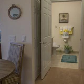 View of a bathroom through an open door, showing interior decor and fixtures.