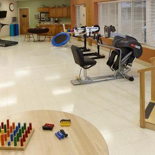 A physical therapy room equipped with various exercise machines and tools for rehabilitation.