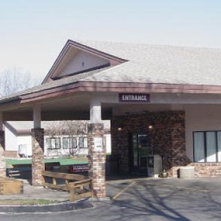 The entrance of a commercial building featuring a stone facade and a sloped roof.
