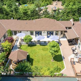 Aerial view of a house with a large backyard, featuring a garden and gazebo.