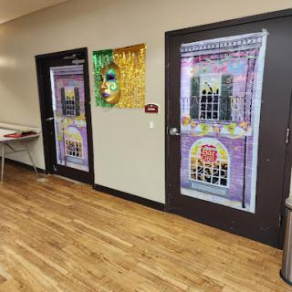 A festive interior featuring decorated doors with a Mardi Gras theme.