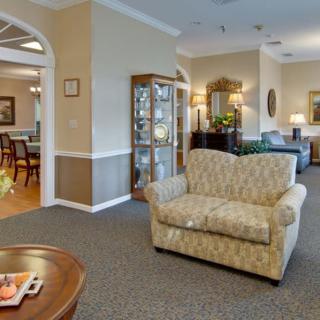 A cozy living room area featuring a patterned sofa and a wooden coffee table, with elegant decor and warm lighting.