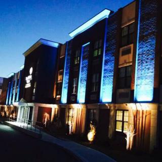 A hotel building illuminated with vibrant lights against a dusky sky.